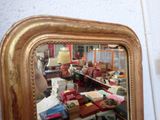 a mirror that has a gold frame on it