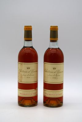deux bouteilles de vin posées l'une à côté de l'autre sur une surface blanche