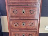 a tall wooden chest of drawers on a carpeted floor