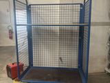 a large blue cage with wheels in a warehouse