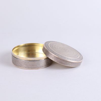 a close up of two silver tins on a white surface