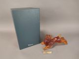 a small figurine of a horse sitting next to a box