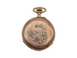 une image représentant une montre de poche en or ornée d'un motif floral