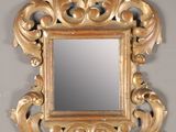a mirror with a gold frame on a wall