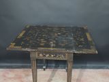 an old table with a black and gold design on it