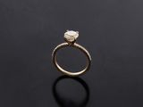 a close up of a gold engagement ring on a black surface