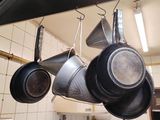 des casseroles et des poêles suspendues au plafond dans une cuisine