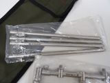 four metal rods and a bag on a table