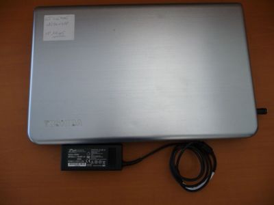 a laptop that is sitting on a table with a charger attached to it