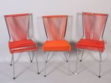 three orange chairs sitting next to each other on a white surface