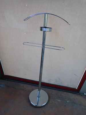a metal pole that has a coat rack on it