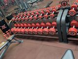 a row of red dumbs on a rack in a gym