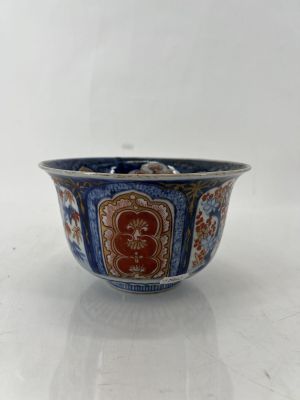 une photo d'un bol bleu et rouge posé sur une table blanche