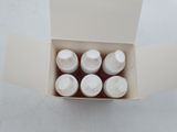 a box with six bottles in it on a table