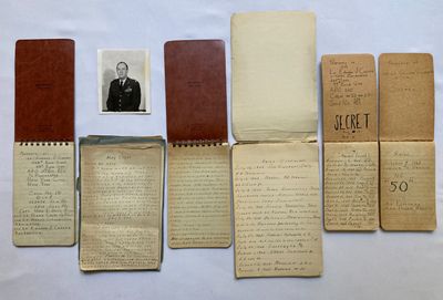 quelques vieux journaux sur lesquels figure la photo d'un homme en costume-cravate