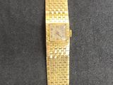 a close up of a gold watch on a black surface