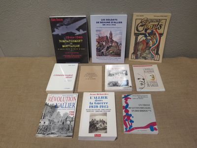 several books are sitting on a table in front of a wall