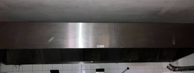 une hotte en acier inoxydable au-dessus d'une cuisinière dans une cuisine