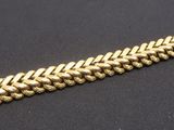 a close up of a gold bracelet on a black surface