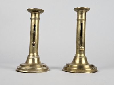 paire de chandeliers anciens en laiton sur fond blanc