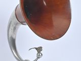 un gramophone en argent et en bois posé sur un socle en bois