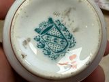 someone is holding a cup with a coat of arms on it