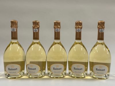 quatre bouteilles de vin blanc sont alignées les unes à côté des autres