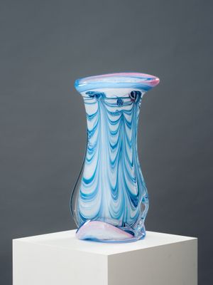 un vase en verre posé sur un socle blanc