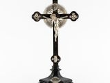 une croix surmontée d'un crâne, posée sur une table