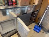 a small refrigerator with a door open in a store