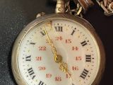 someone is holding a pocket watch with roman numerals on it