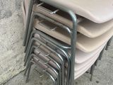 un grand nombre de chaises empilées contre un mur