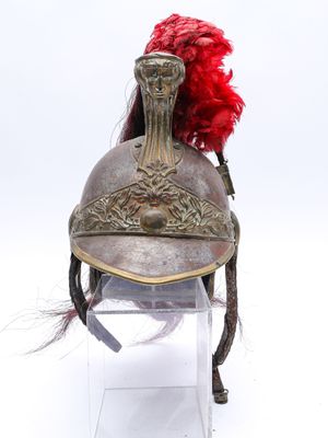 un vieux casque surmonté d'une plume rouge