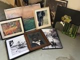 de nombreux tableaux encadrés posés par terre à côté d'un vase