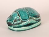 a small statue of a turtle on a white surface