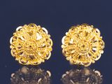 une paire de boucles d'oreilles en or sur une surface noire