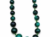 a close up of a green beaded necklace on a white background