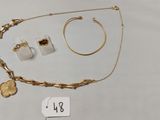 un gros plan sur un collier, un bracelet et une bague posés sur une table