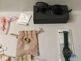 many items that are on the table including a watch, bracelets, and other items