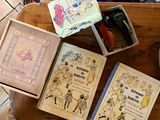 trois livres posés sur un plateau en bois posé par terre