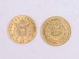 two gold coins sitting side by side on a white surface