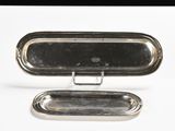 two silver trays sitting on top of each other on a white surface
