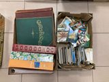 a box full of books on the floor next to a pile of books