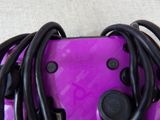 a close up of a purple controller with black wires
