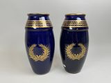 une paire de vases bleus ornés de motifs dorés sur fond blanc