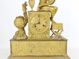une horloge en or sur laquelle est assis un homme