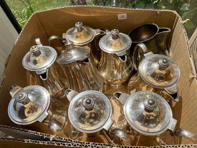 une boîte en carton remplie de théières argentées et de théières