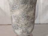 un vase posé sur une table à fond blanc