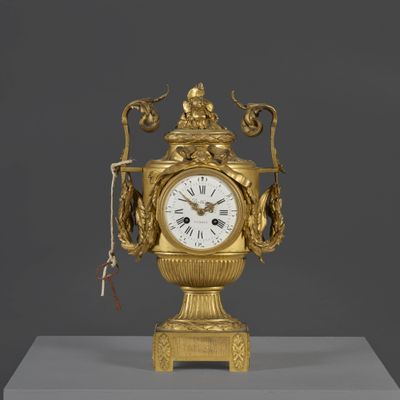 une horloge en or posée sur un socle