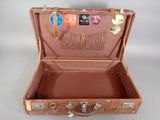 a brown suitcase with stickers on it sitting on a table